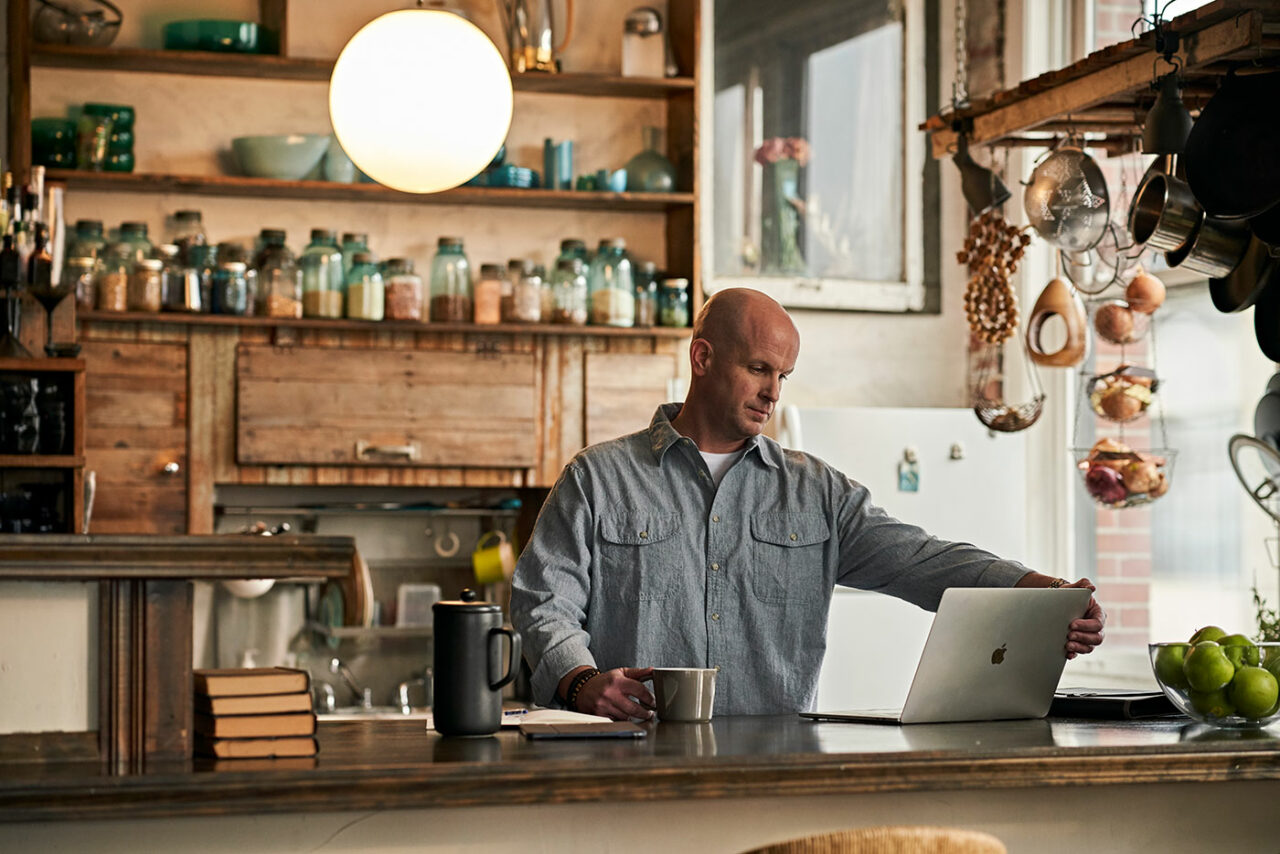 man working from home in kitchen on laptop